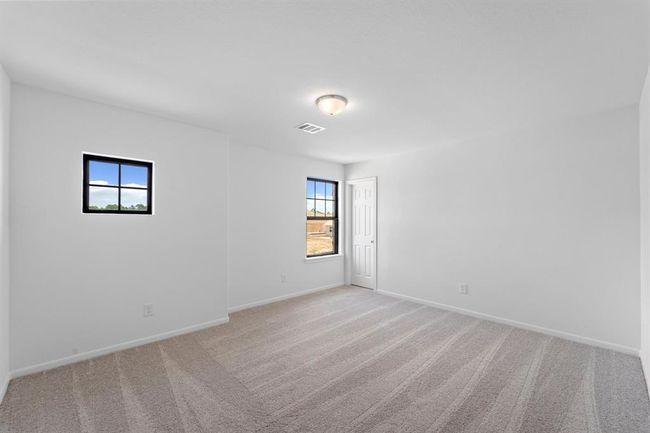 Your secondary bedroom features plush carpet, fresh paint, closet, and a large window that lets in plenty of natural lighting. | Image 16