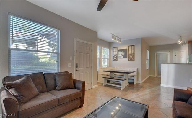 Living area with baseboards, light tile patterned floors, and ceiling fan | Image 7