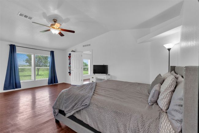 Bedroom featuring vaulted ceiling, wood finished floors, and a ceiling fan | Image 17