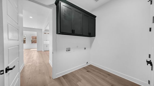 Laundry area with electric dryer hookup, light wood-style flooring, cabinet space, baseboards, and hookup for a washing machine | Image 20