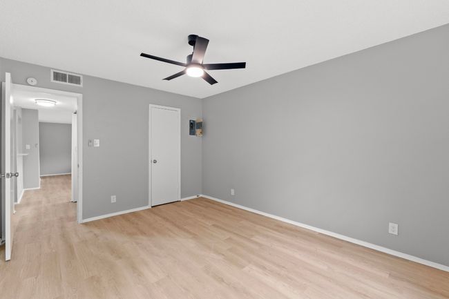 Unfurnished bedroom featuring baseboards, a ceiling fan, visible vents, and light wood-style floors | Image 15