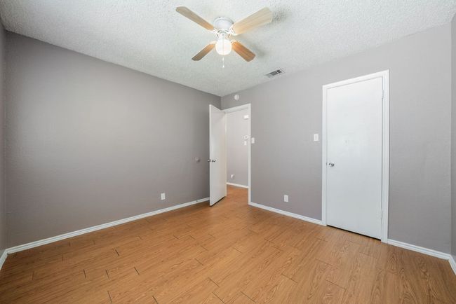 Unfurnished bedroom featuring a textured ceiling, light wood finished floors, and a ceiling fan | Image 29