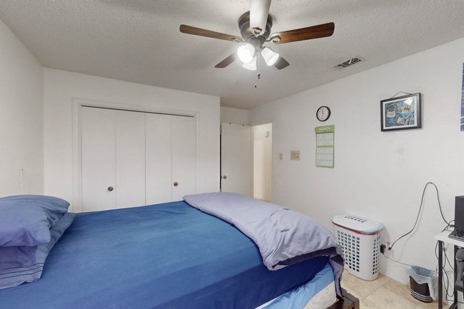 Bedroom with a ceiling fan, visible vents, a closet, and a textured ceiling | Image 24
