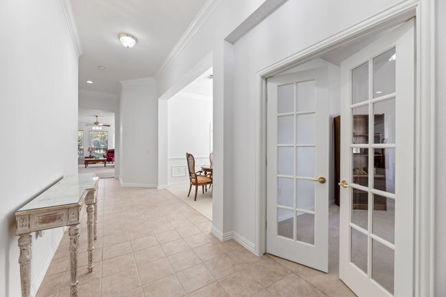 Hall with light tile patterned flooring, ornamental molding, and french doors | Image 8