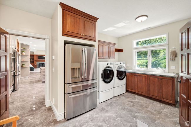 Washroom with washing machine and clothes dryer, light marble finish floors, and cabinet space | Image 15