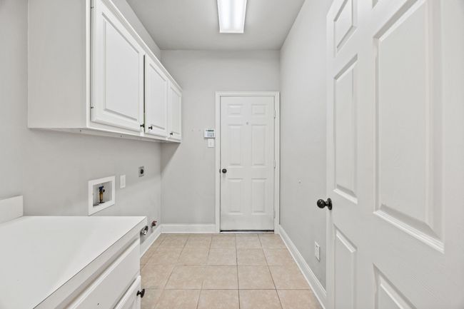 Laundry room with numerous storage cabinets. | Image 17