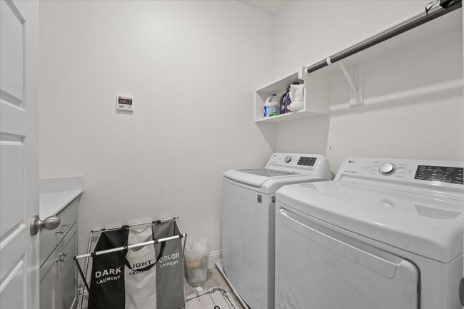 Washroom featuring washing machine and clothes dryer and cabinet space | Image 18