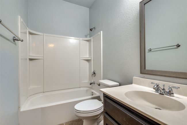 Bathroom with vanity, shower / bath combination, and a textured wall | Image 17