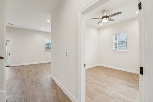 Hall with recessed lighting, wood plank tile floor, visible vents, and baseboards | Image 18