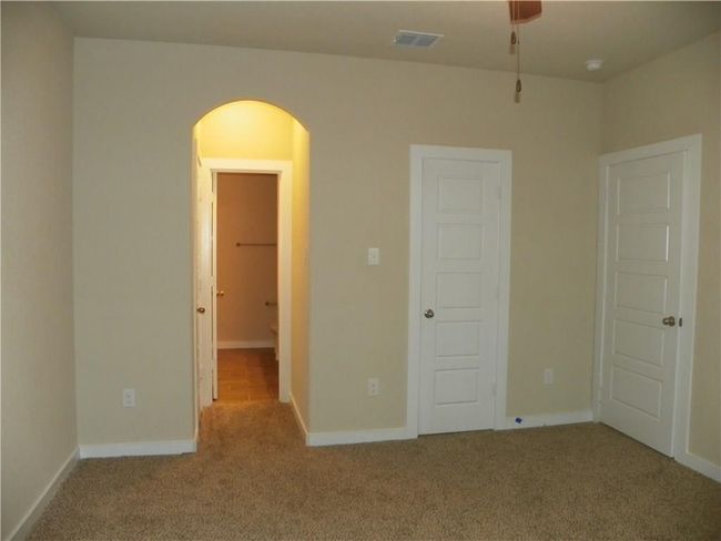 Unfurnished bedroom with carpet floors, arched walkways, and baseboards | Image 8
