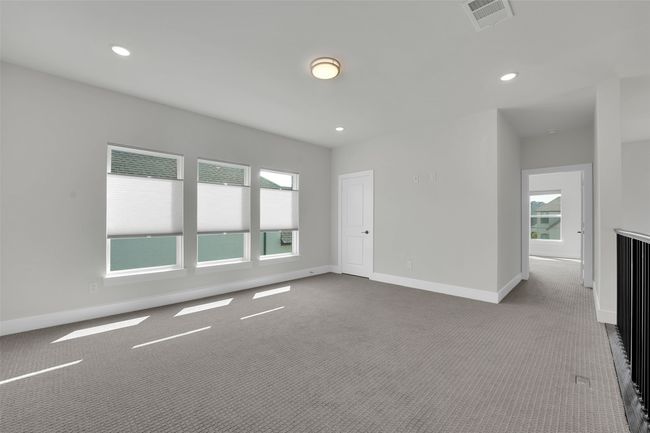 Unfurnished room featuring dark carpet, plenty of natural light, visible vents, and baseboards | Image 33
