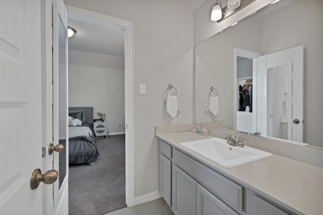 Bathroom with vanity, a walk in closet, baseboards, tile patterned floors, and connected bathroom | Image 31