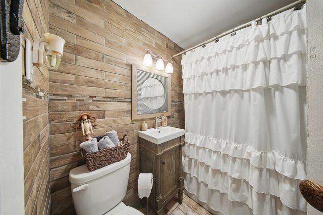 Bathroom featuring toilet, vanity, and a shower with shower curtain | Image 28