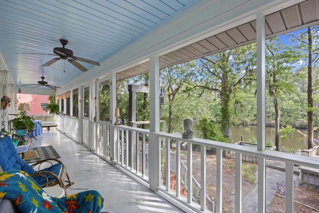 View of patio featuring a ceiling fan, a water view, and view of wooded area | Image 26