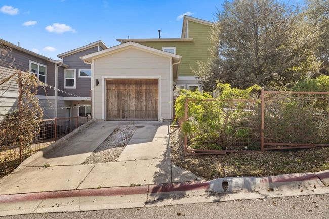 View of front of house featuring a garden, driveway, fence, and an attached garage | Image 27