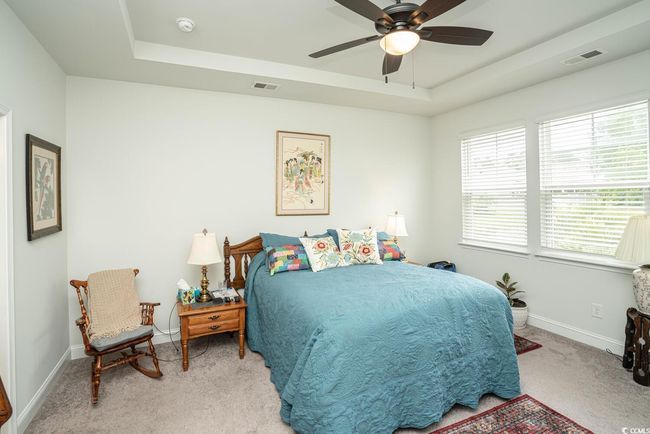 Bedroom with a raised ceiling, carpet flooring, baseboards, and ceiling fan | Image 32