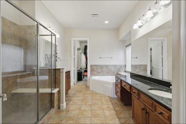 Ensuite bathroom featuring two vanities, a jetted tub, and a shower stall | Image 24