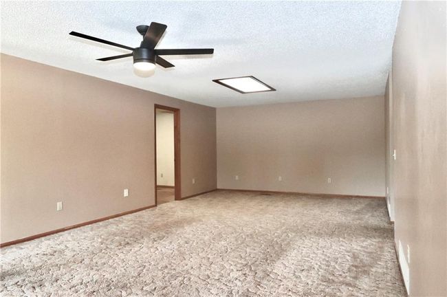 Carpeted empty room with a textured ceiling and ceiling fan | Image 25