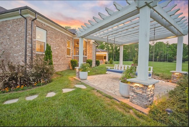 A dreamy pergola with a large swing, stone accents, and a peaceful waterfall backdrop—your own private retreat right in the backyard. | Image 5
