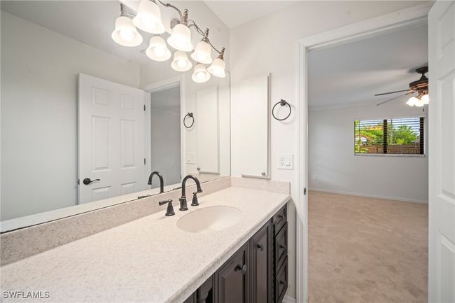 Bathroom with vanity, ceiling fan, and a chandelier | Image 16