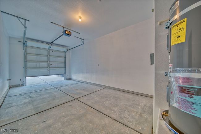 Spacious remote controlled single-car garage with dedicated hot water heater storage for added convenience. | Image 8