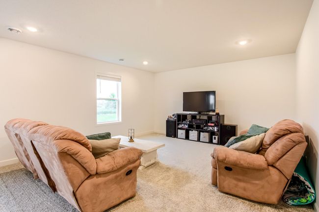 Cozy family room complete with ample seating and room for a large-screen setup. | Image 33