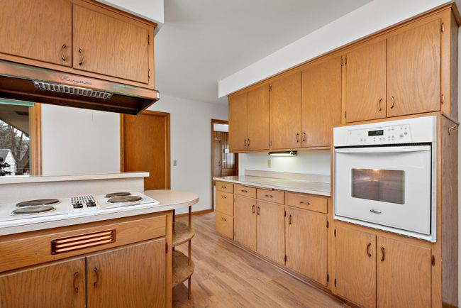Nice kitchen with Jenn-Air cooktop for cooking and grilling, vent hood, wall oven, eat in kitchen/dining area and easy access to main floor laundry! | Image 21