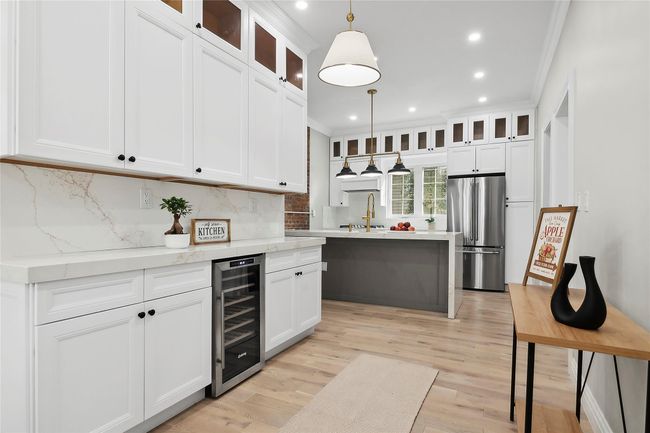 Kitchen featuring freestanding refrigerator, wine cooler, recessed lighting, crown molding, and backsplash | Image 8