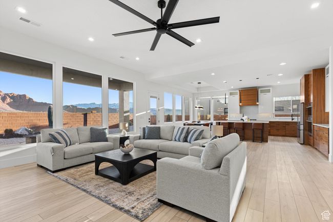 Living room featuring a mountain view, visible vents, ceiling fan, light wood-type flooring, and recessed lighting | Image 7