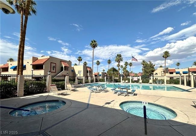 Community pool featuring a hot tub, a residential view, and a patio area | Image 18