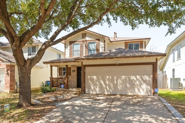 Traditional-style home with brick siding, cooling unit, concrete driveway, and a garage | Image 4