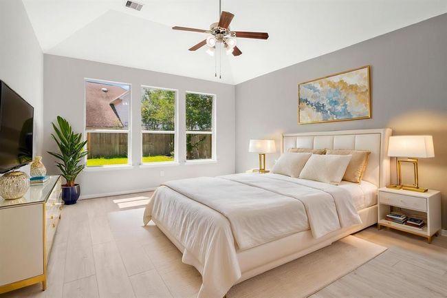 Retreat to a spacious master suite featuring dramatic vaulted ceilings that create an open, airy feel. This serene space offers plenty of room for a sitting area or oversized furniture. The en suite bathroom boasts a spa-like atmosphere with dual vanities, a soaking tub, separate glass-enclosed shower, and a generous walk-in closet—providing the perfect blend of luxury and comfort. | Image 15
