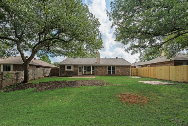 Rear view of house with a chimney, a patio area, and brick siding | Image 20