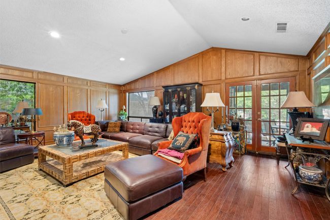 Living area with wood-type flooring, lofted ceiling, visible vents, and plenty of natural light | Image 4