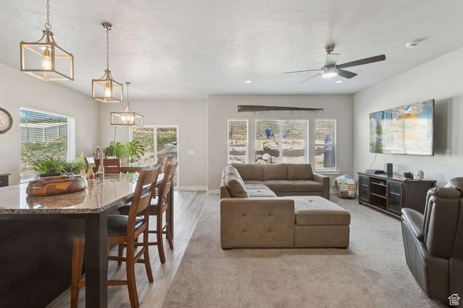 Living room with a ceiling fan, healthy amount of natural light, and light wood-style flooring | Image 13