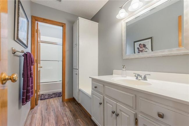 Bathroom with wood finished floors, vanity, and shower / bath combination with glass door | Image 52