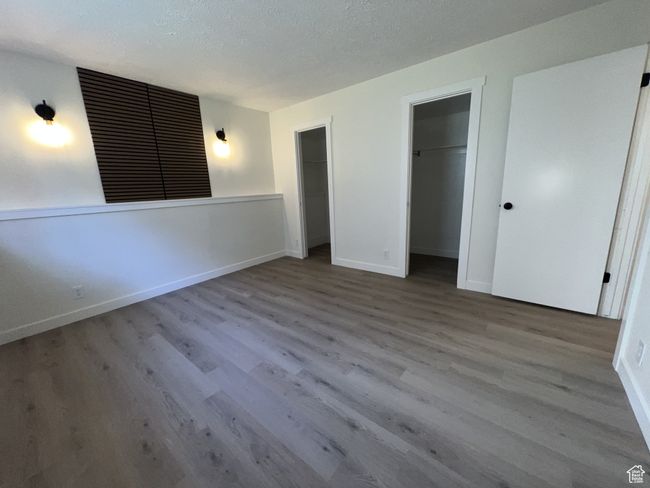 Unfurnished bedroom with wood finished floors, baseboards, and a textured ceiling | Image 10
