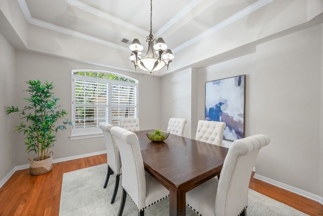 The formal dining room sits at the front of the home with windows overlooking the charming courtyard. Its close proximity to the kitchen makes hosting and entertaining effortless. | Image 16