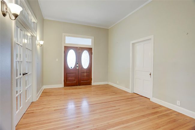 ANOTHER VIEW OF THE GRAND FOYAR FACING DOUBLE DOORS FEATURING A TRANSOMED WINDOW SHOWCASING ANTIQUE OVAL WINDOWS. LOW UTILITY BILLS-BUILT TO LAST, WITH CYPRESS WOOD. | Image 6