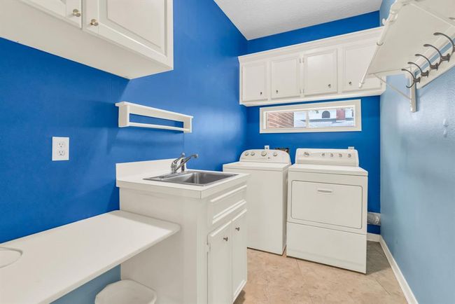 Laundry room has a sink and folding table, as well as extra storage. | Image 13
