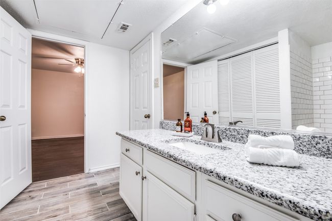 Bathroom with vanity, wood finished floors, ceiling fan, a closet, and baseboards | Image 9