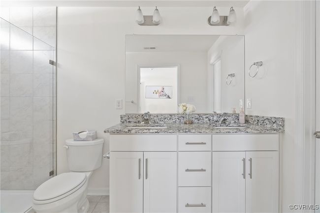 Bathroom with visible vents, a sink, toilet, and a shower stall | Image 19