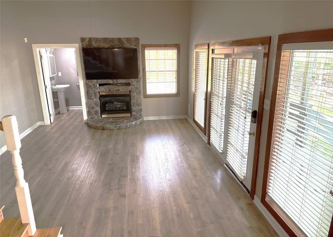 Cozy living room featuring a charming stone propane fireplace. | Image 19