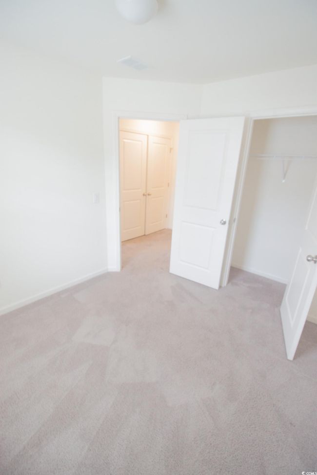 Unfurnished bedroom featuring light colored carpet, baseboards, and a closet | Image 21