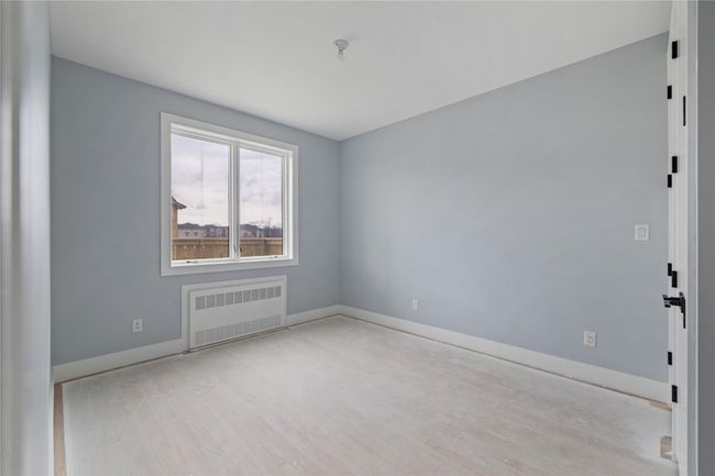 Empty room featuring radiator heating unit, wood finished floors, and baseboards | Image 38