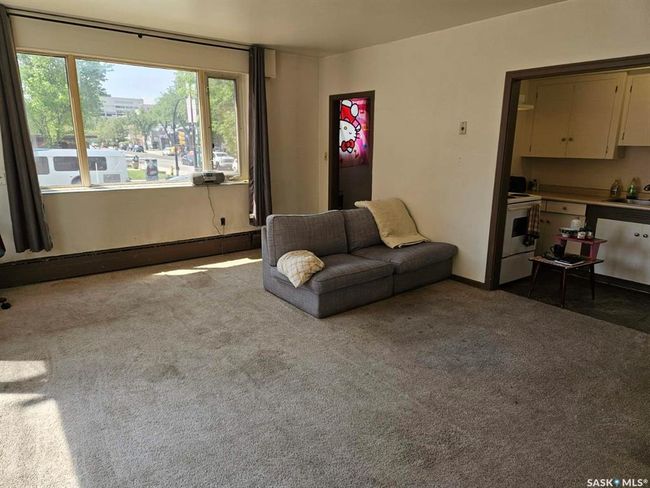 Living area featuring dark colored carpet and a baseboard heating unit | Image 5