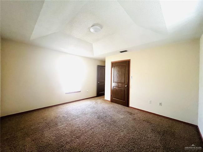 Unfurnished room featuring a textured ceiling, a tray ceiling, and carpet floors | Image 16