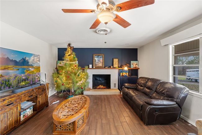 Living room with ceiling fan, dark hardwood / wood-style flooring, and a brick fireplace | Image 4