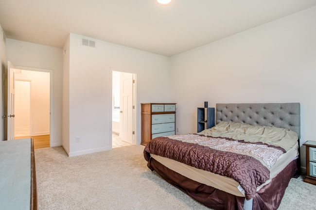 Generous layout in the primary suite with direct access to a private ensuite bath and walk-in closet. | Image 18