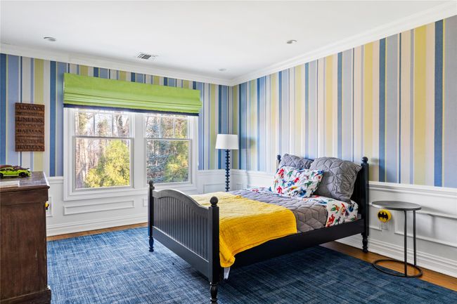 Bedroom with wood finished floors, visible vents, and a wainscoted wall | Image 37